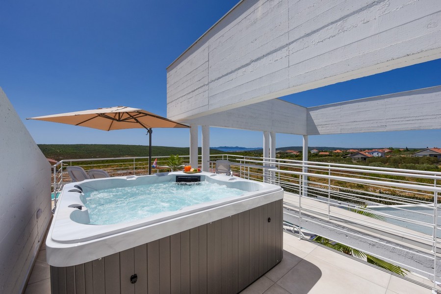 Venkovní vířivka na horní terase s výhledem do krajiny a na moře.