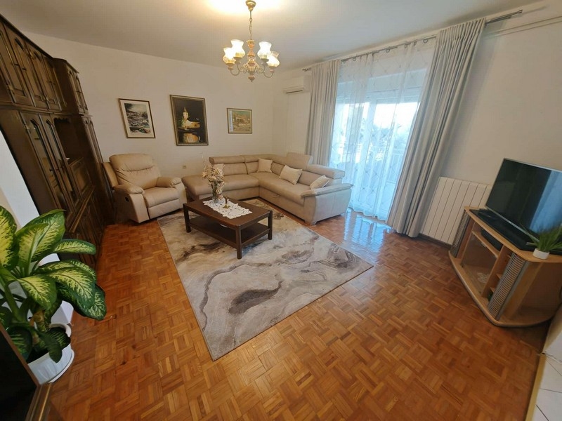 Obývací pokoj s gaučem a TV.