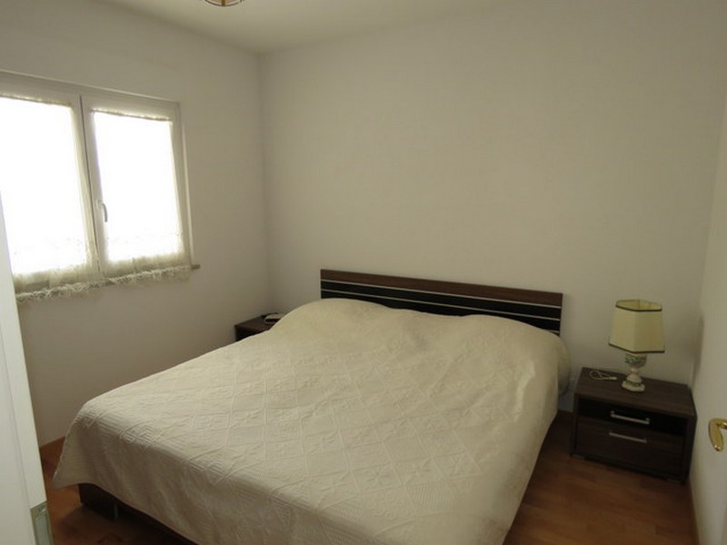 Ložnice s manželskou postelí a nočními stolky.