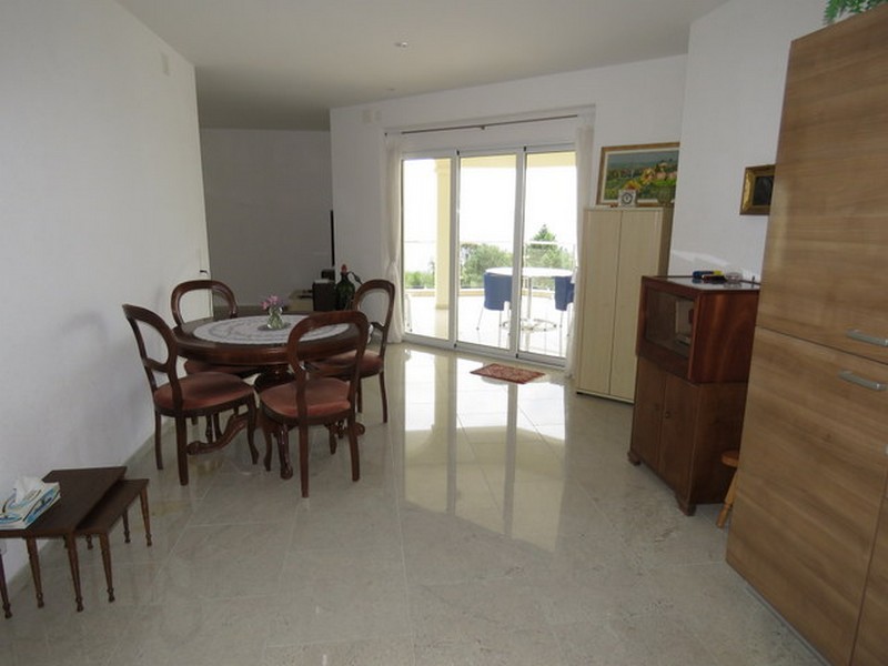 Jídelna s kulatým stolem a přístupem na terasu s výhledem na moře.