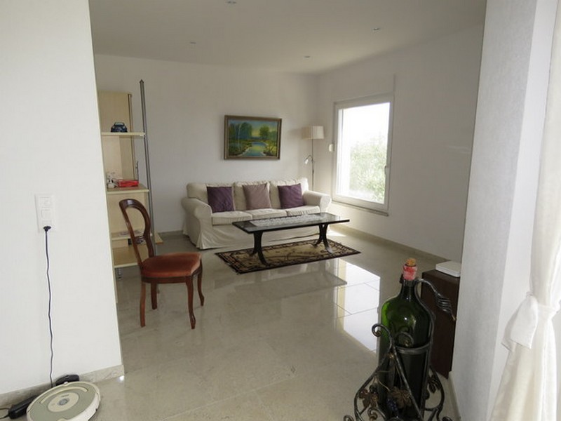 Obývací pokoj s pohovkou, konferenčním stolkem a velkým oknem.