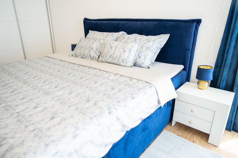 Ložnice s modrou postelí a nočními stolky