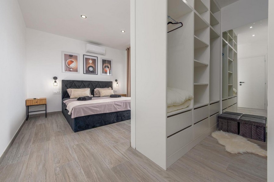 Velká ložnice s integrovanou skříní a moderním interiérem.