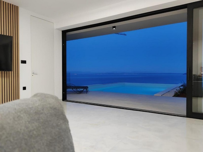 Obývací pokoj s výhledem na bazén a moře