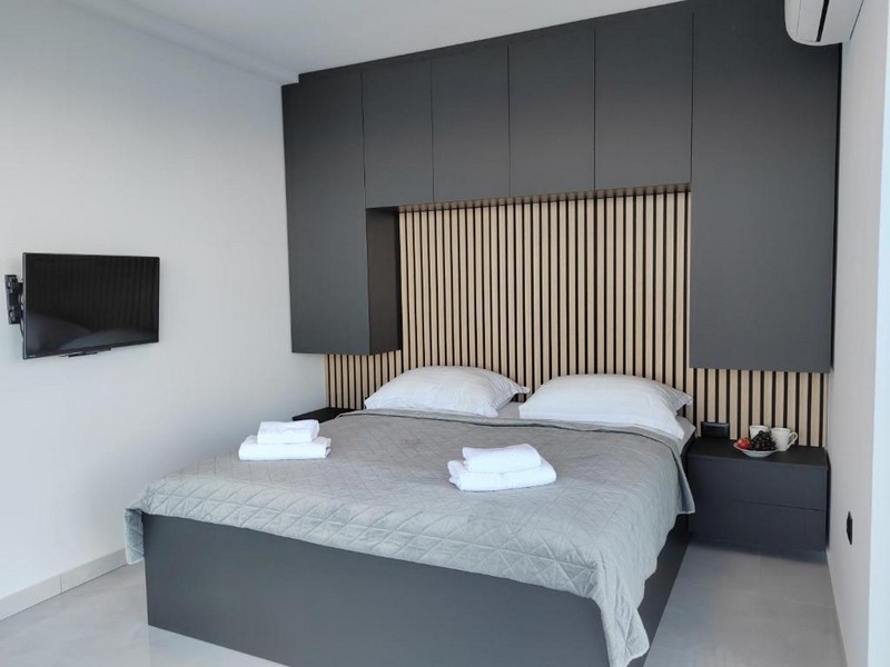 Manželská postel v ložnici s dřevěnými detaily