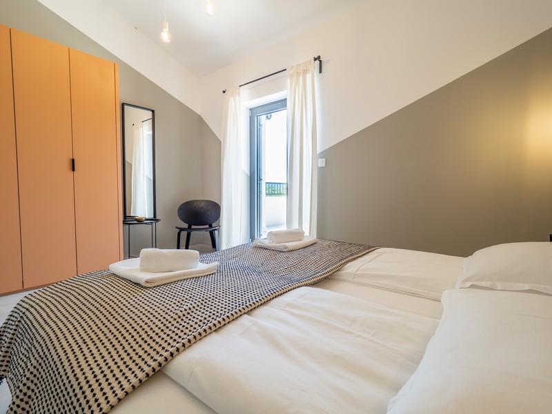 Ložnice s manželskou postelí a vstupem na balkon