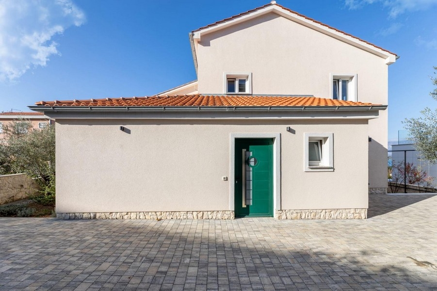 Vstupní prostor bytového domu se zelenou vstupní branou