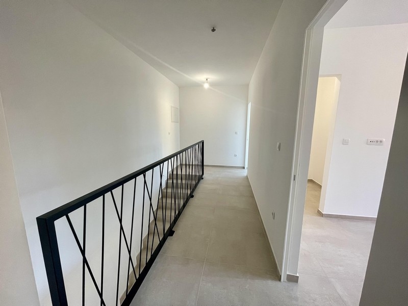 Chodba s moderním schodištěm a vstupem do ložnic