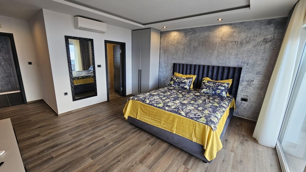 Ložnice s manželskou postelí a decentním designem stěn