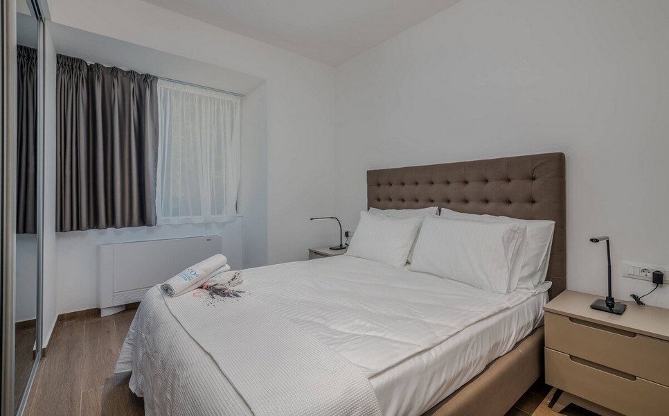 Útulná ložnice s oknem a zatemňovacími závěsy