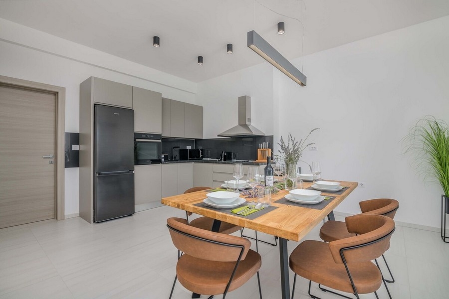 Jídelní kout s designovým stolem a moderní kuchyní