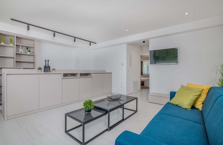 Druhý obývací pokoj se stylovou pohovkou a TV