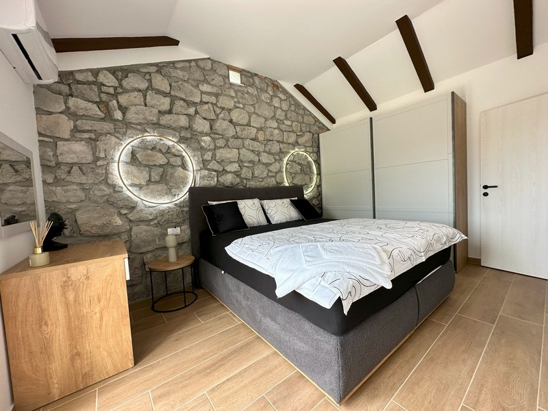 Ložnice s kamennou zdí a moderními akcenty