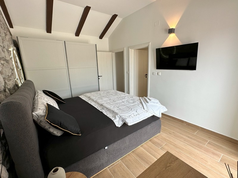 Ložnice s TV a dřevěným stropem