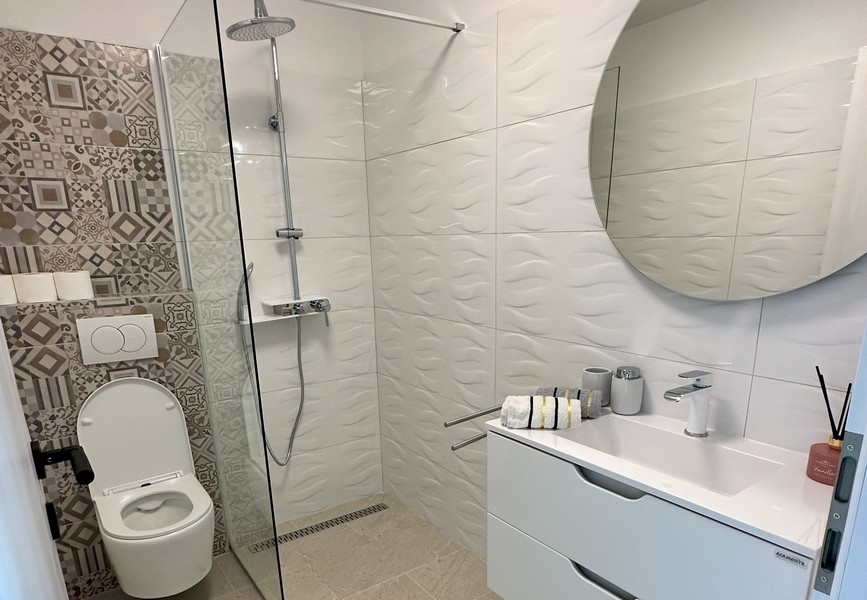 Moderní koupelna se sprchovým koutem a elegantním nábytkem