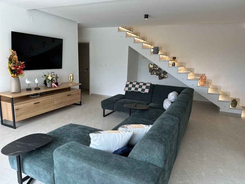 Obývací pokoj s elegantním schodištěm a dekorací