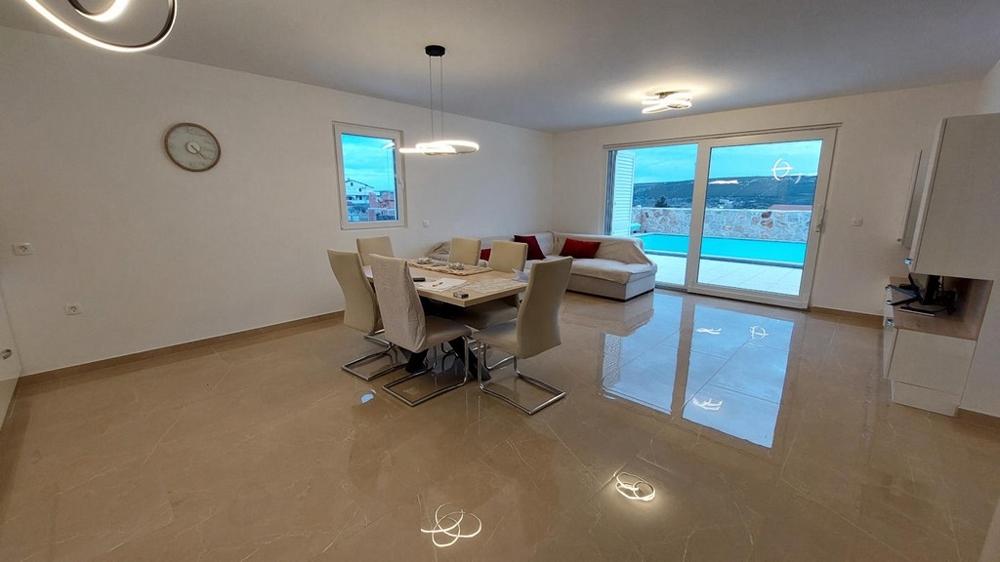 Otevřený obývací prostor s jídelním stolem a výhledem na bazén, nemovitost H3491