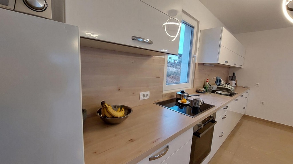 Detail zařízené kuchyně s pracovní plochou a spotřebiči