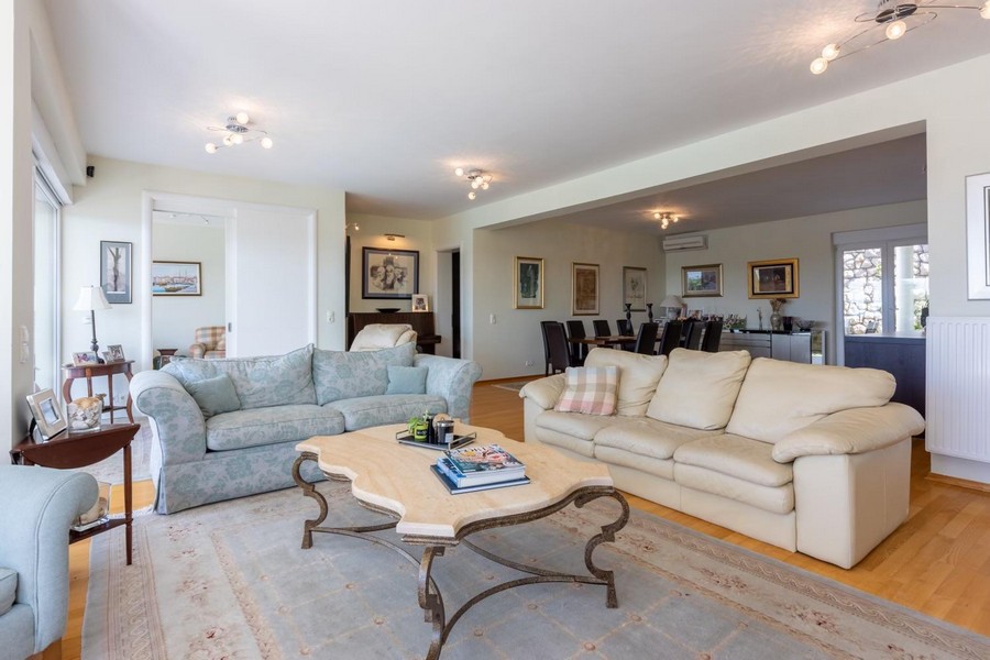 Prostorný obývací pokoj s panoramatickými okny, výhled na moře