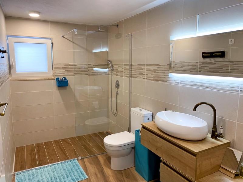 Koupelna s velkým sprchovým koutem a moderními obklady