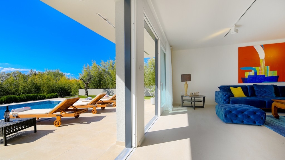 Pohled ze salonku na bazén a živý plot v Kvarnerském zálivu.