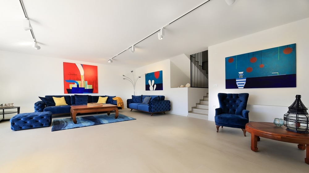 Výhled ze střešní terasy nemovitosti s bazénem a salonkem a do okolí s mořem.