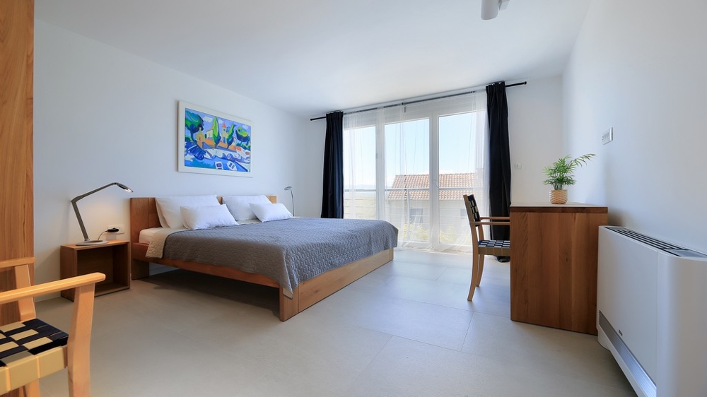 Pohled do obývacího pokoje s kvalitním nábytkem a východem na terasu s bazénem.