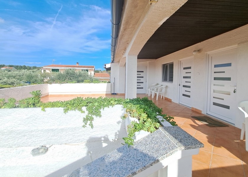 Balkon s rostlinami a dvěma dveřmi do studia.