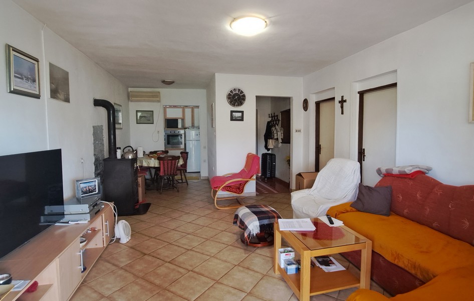 Obývací pokoj s jídelnou a kuchyní v pozadí.