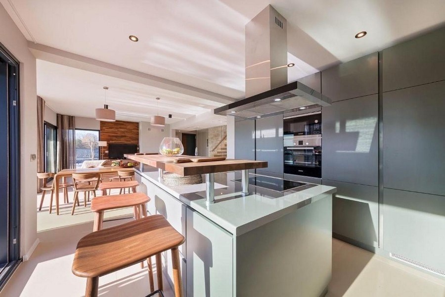 Moderní otevřená kuchyně s ostrůvkem a barovými stoličkami