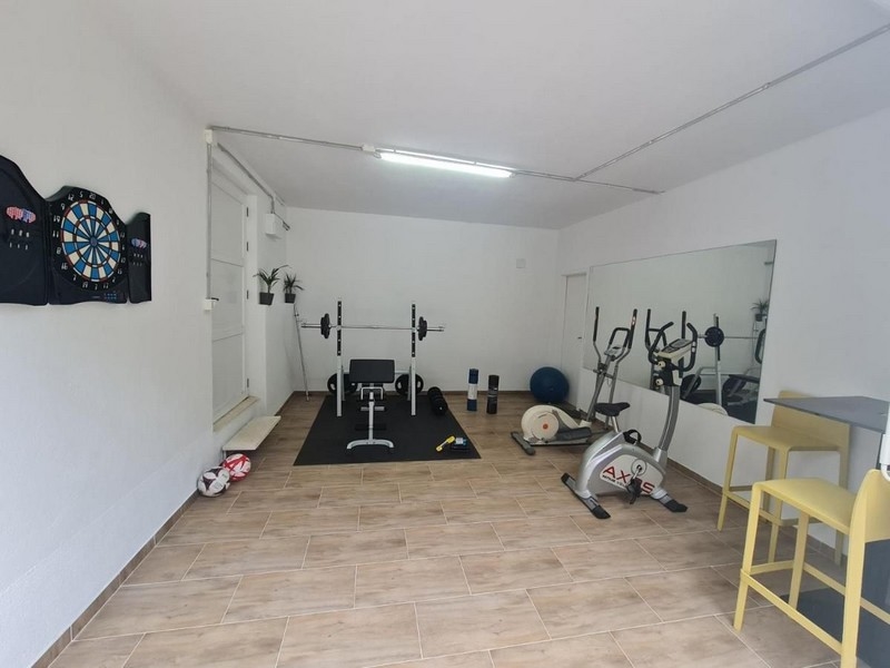 Posilovna se sportovním vybavením a terčem na šipky