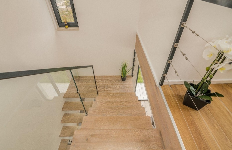 Dřevěné schody se skleněným zábradlím a rostlinami