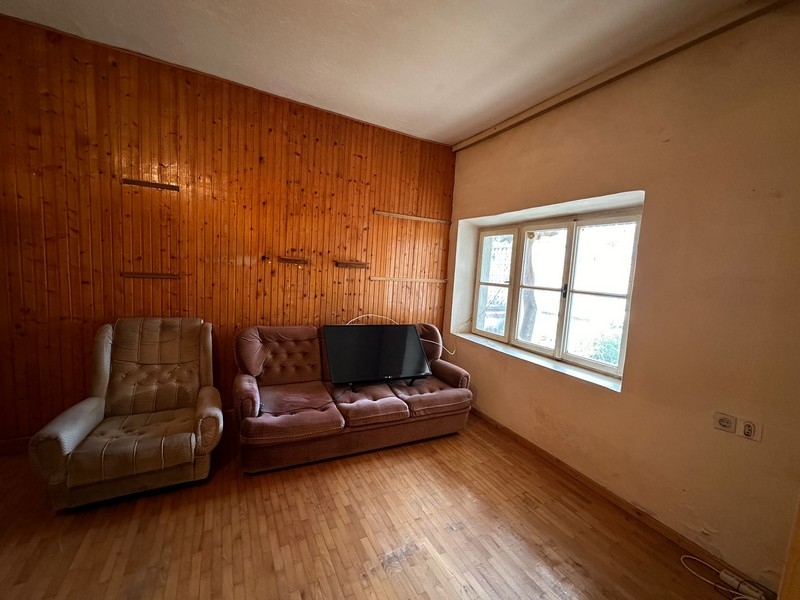 Starý obývací pokoj s dřevěným obložením.