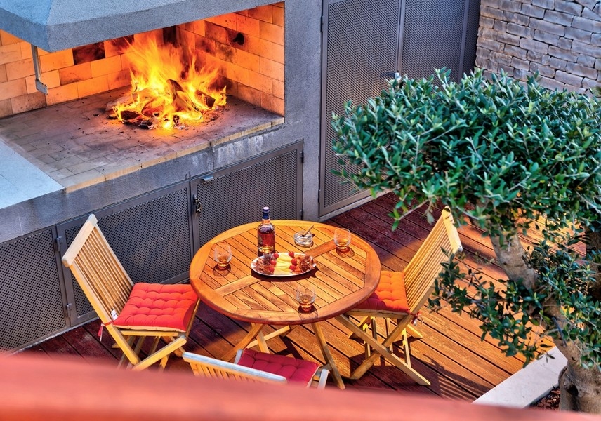 Útulný venkovní prostor s krbem a posezením