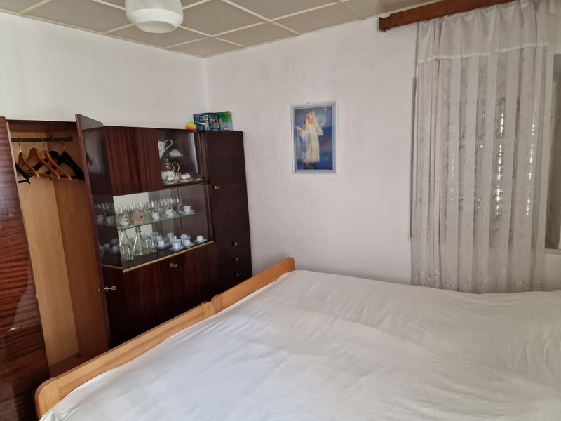 Ložnice s manželskou postelí, stěnou a nástěnnou malbou