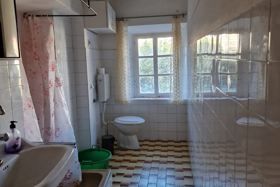 Koupelna s oknem, sprchovým koutem, umyvadlem a toaletou