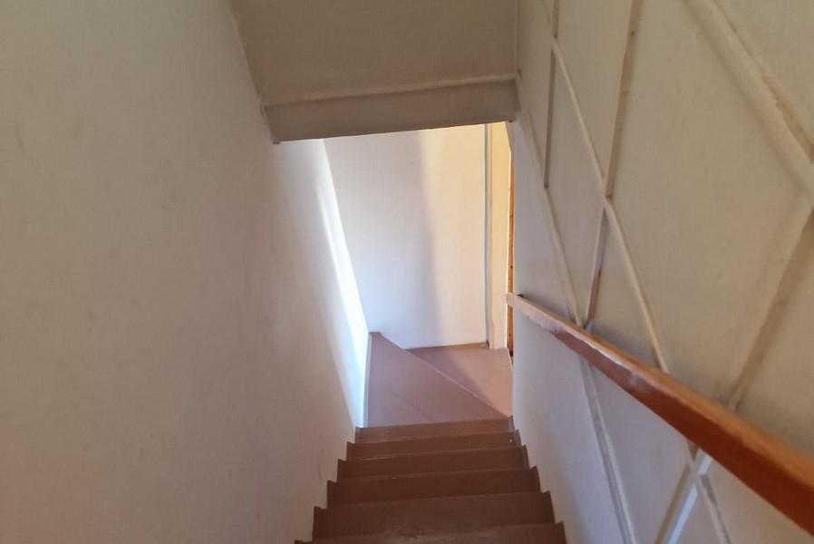 Úzké schodiště s dřevěným zábradlím