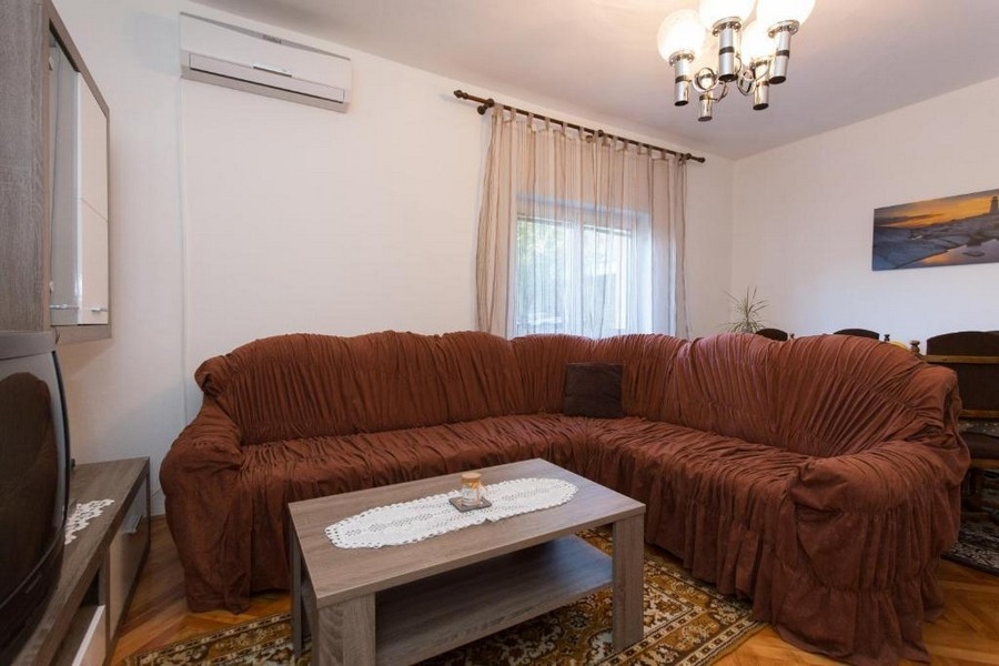 Obývací pokoj s velkou pohovkou a klimatizací