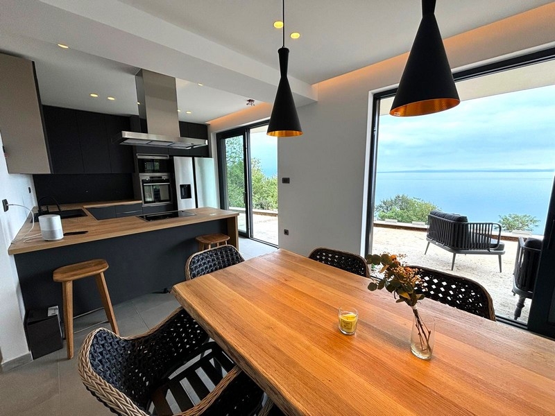 Moderní kuchyně s jídelním koutem a výhledem na moře