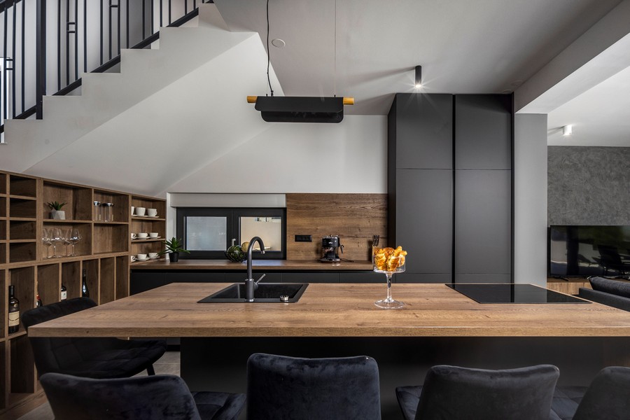 Moderní kuchyně s dřevěným pultem a černými prvky