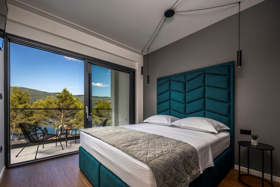 Ložnice s velkou postelí a panoramatickým oknem