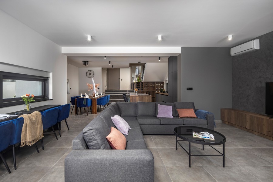 Moderní obývací pokoj s šedou pohovkou a jídelním koutem