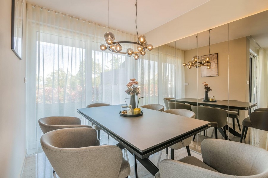 Útulný jídelní kout s čalouněnými židlemi a designovými světly