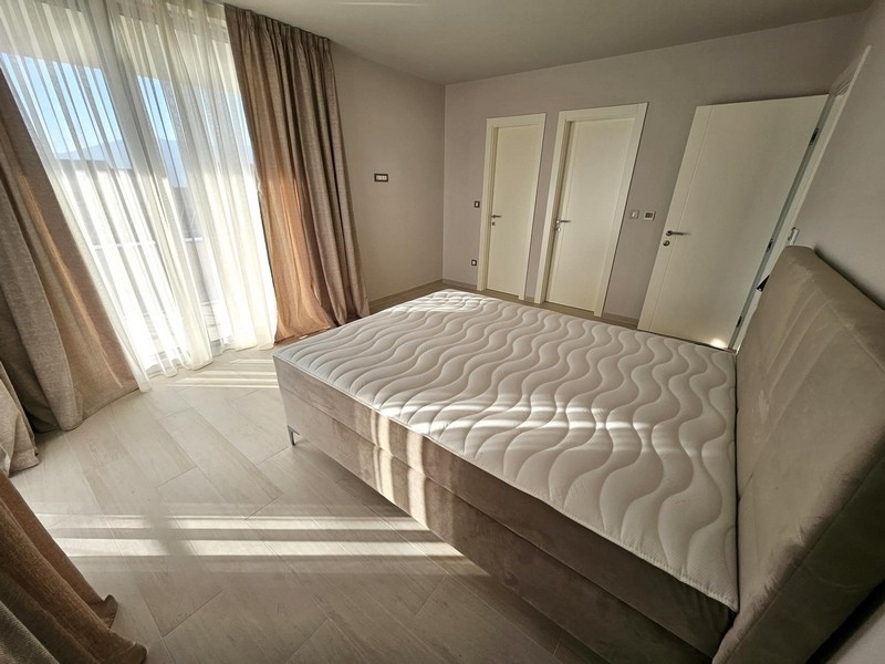 Prostorná ložnice s velkými okny a manželskou postelí