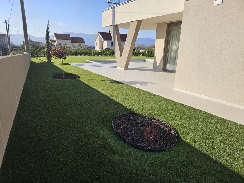 Moderní zahrada s trávníkem a terasou vily na Krku