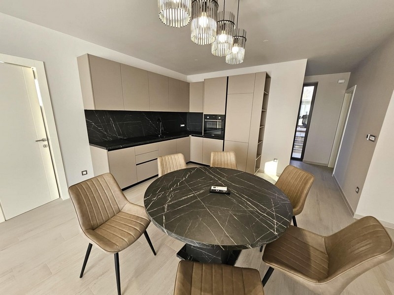 Moderní kuchyně s černými pracovními plochami a kulatým jídelním stolem