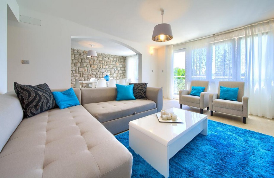 Moderní obývací pokoj s velkou pohovkou a výhledem na moře