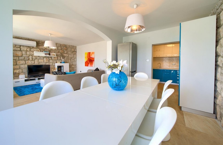 Otevřený obývací a jídelní kout se stěnou z přírodního kamene