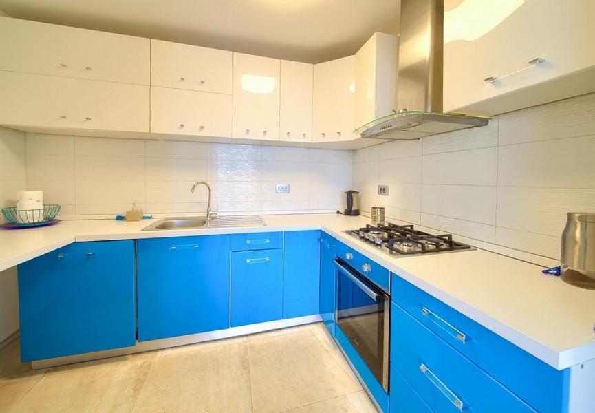 Kuchyně s modrými skříňkami a moderním vybavením