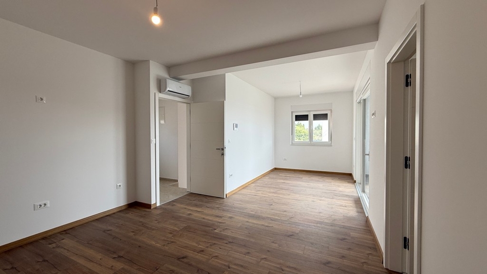 Světlý obývací pokoj s parketami a velkými okny